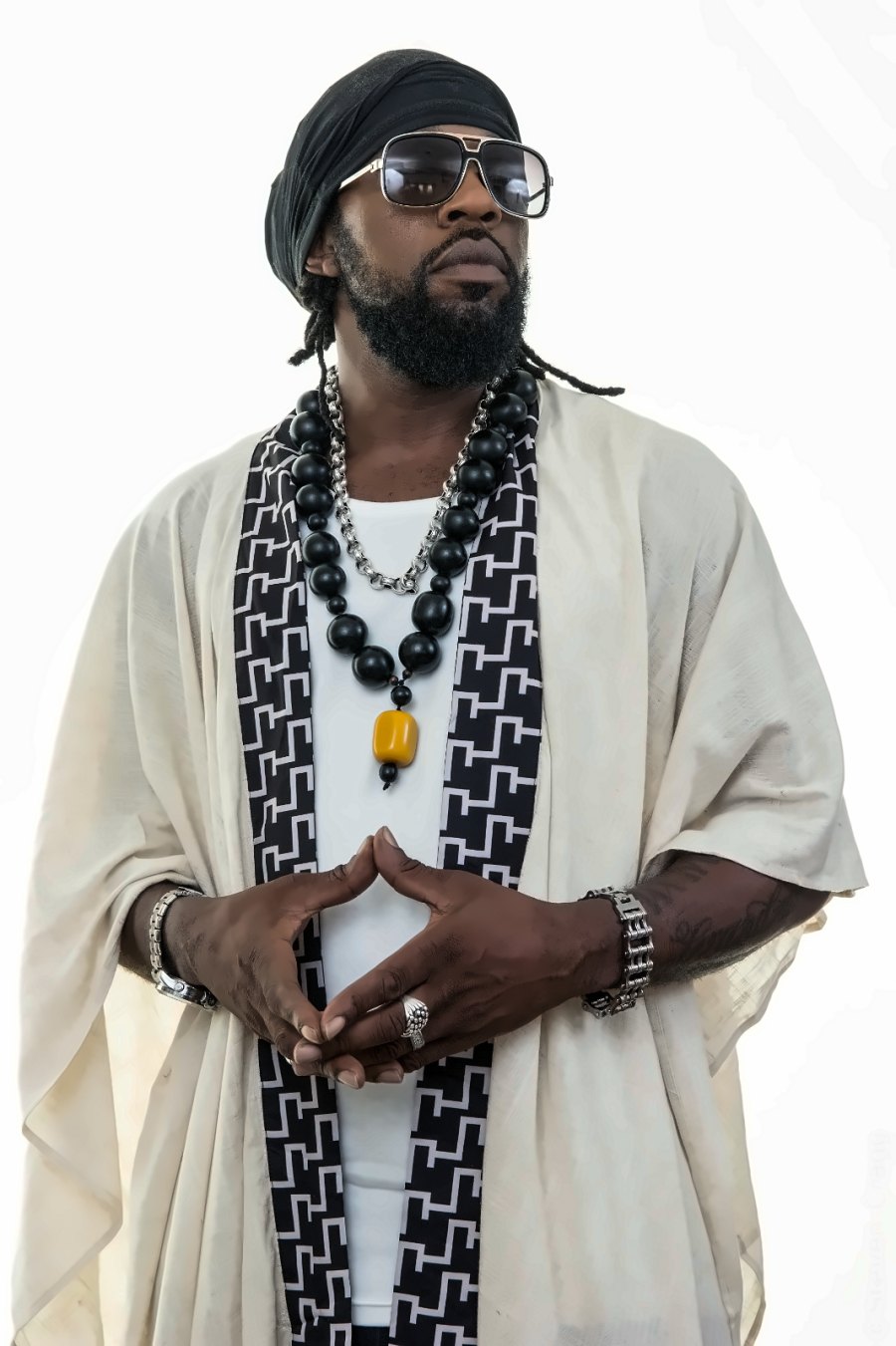 Portrait of Mr Roach in a cream robe, head wrap and sunglasses